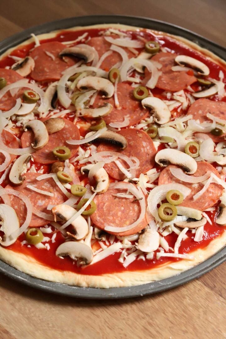 homemade pizza dough with toppings before baking