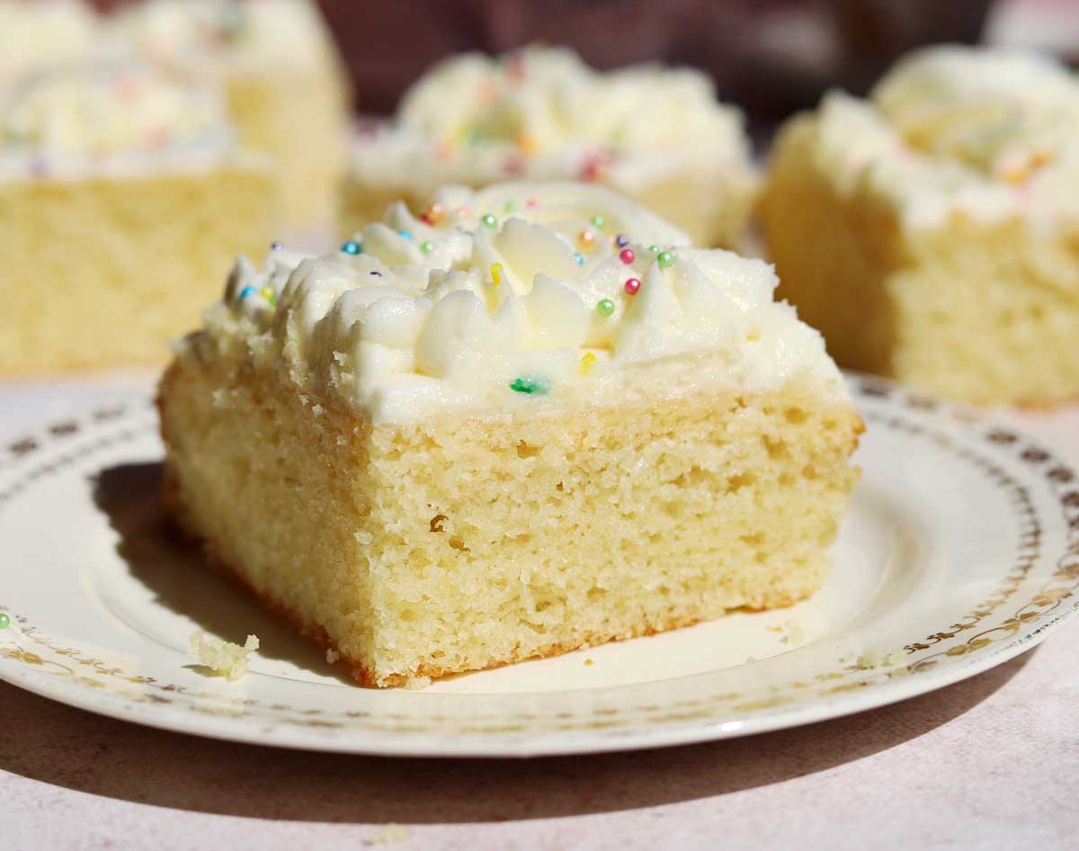 slice of moist vanilla sheet cake on a plate