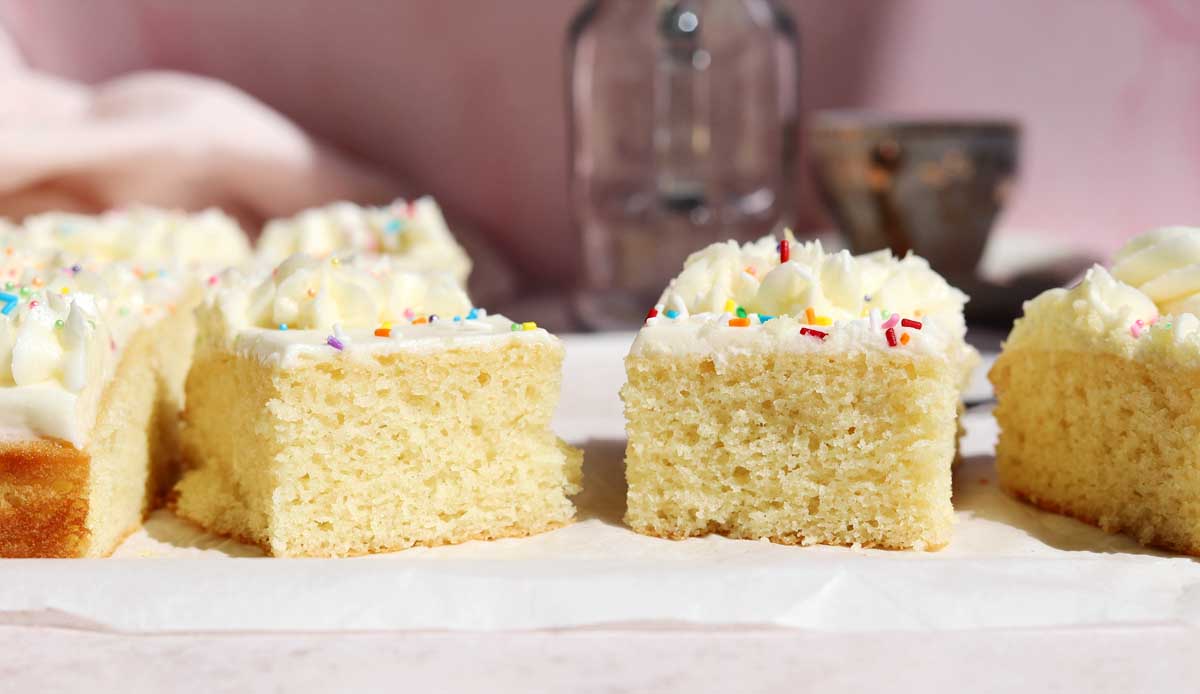 slices of moist vanilla sheet cake on parchment paper