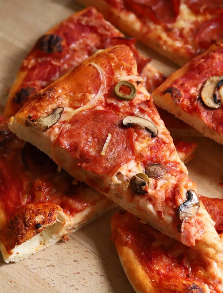 slice of homemade pizza with pepperoni, mushrooms and cheese