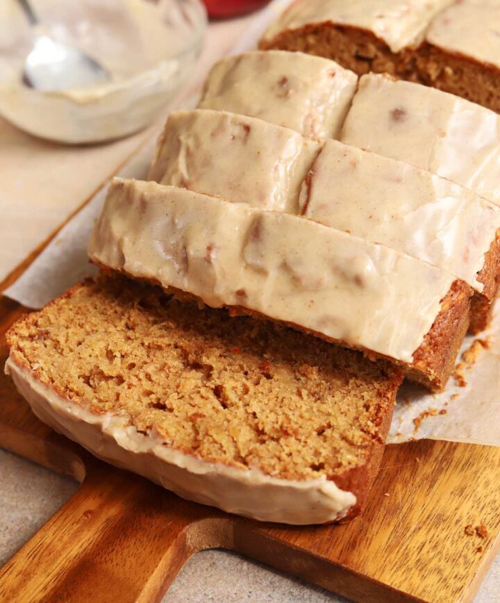 angle view of brown butter apple bread sliced on cutting board with brown butter icing