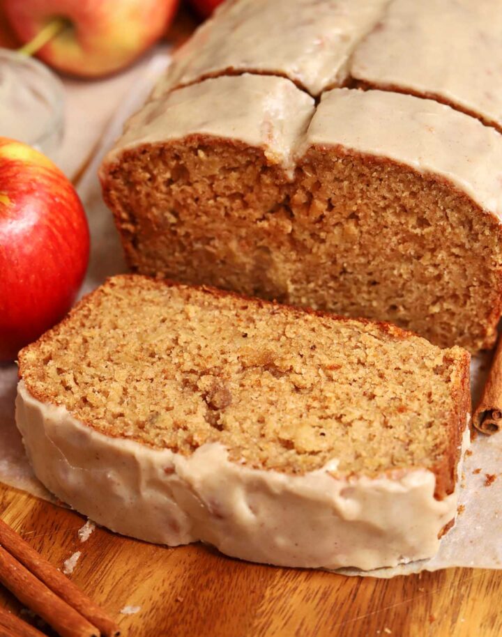 brown butter apple bread sliced on cutting board with brown butter icing
