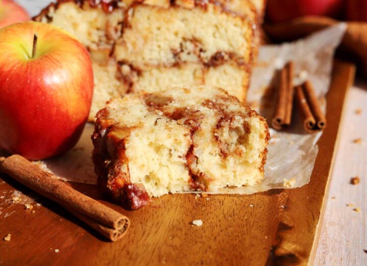 cinnamon apple fritter bread slice broken in half showing the gooey cinnamon apple filling