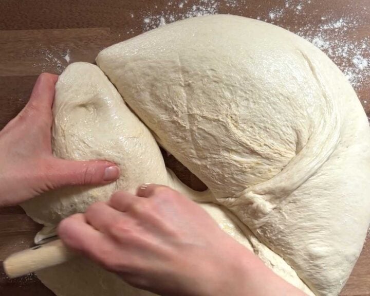 Transfer the proofed dough to a work surface and divide into 4 equal portions.