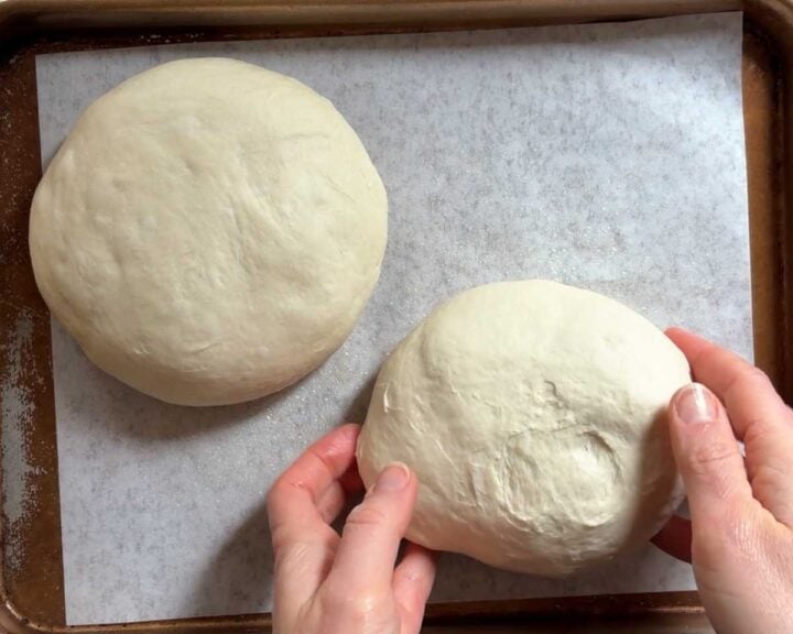 Shape into tight balls and transfer to a parchment-lined baking sheet, cover and let rise again for about 30 minutes.