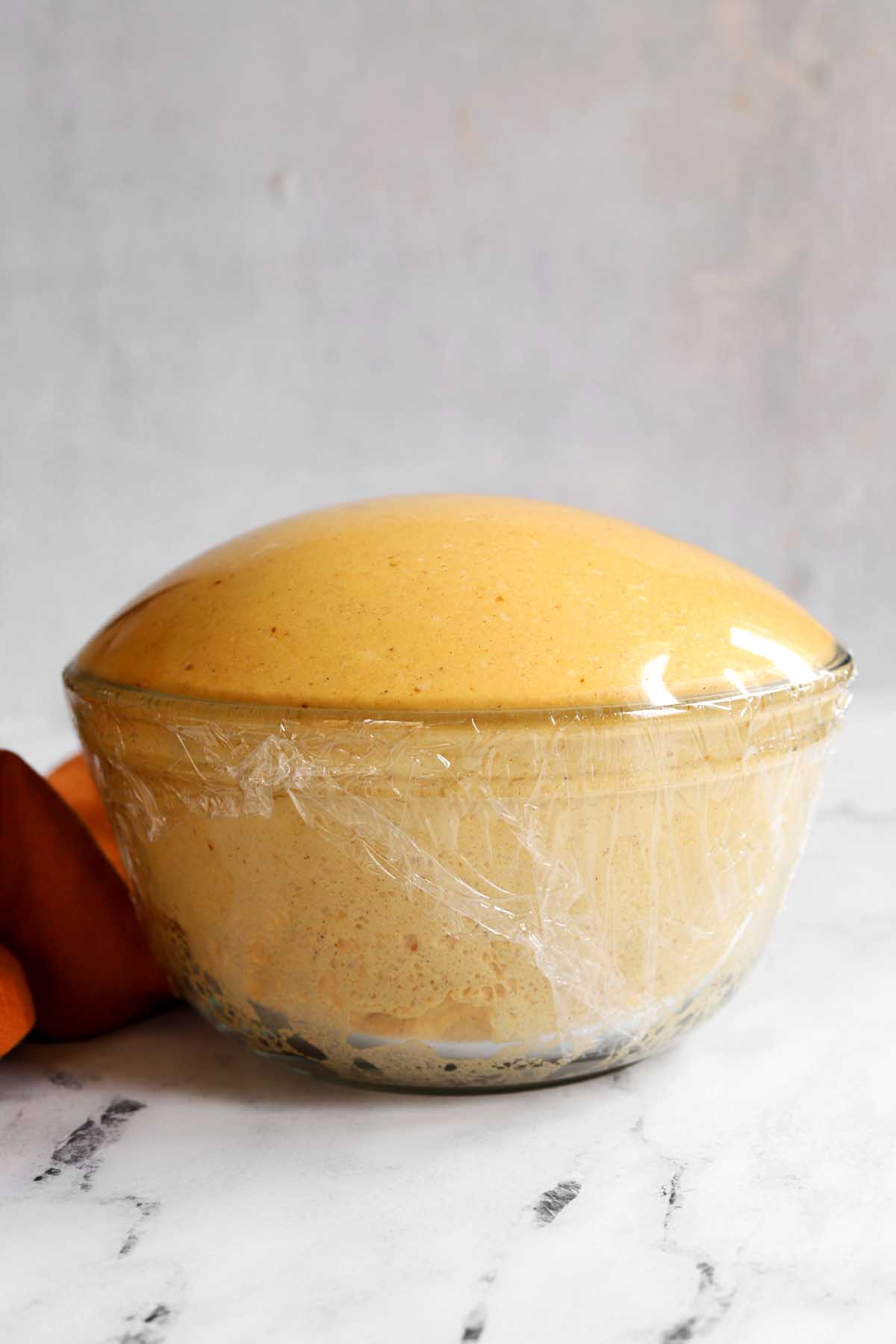 pumpkin cinnamon roll dough after rising in a bowl