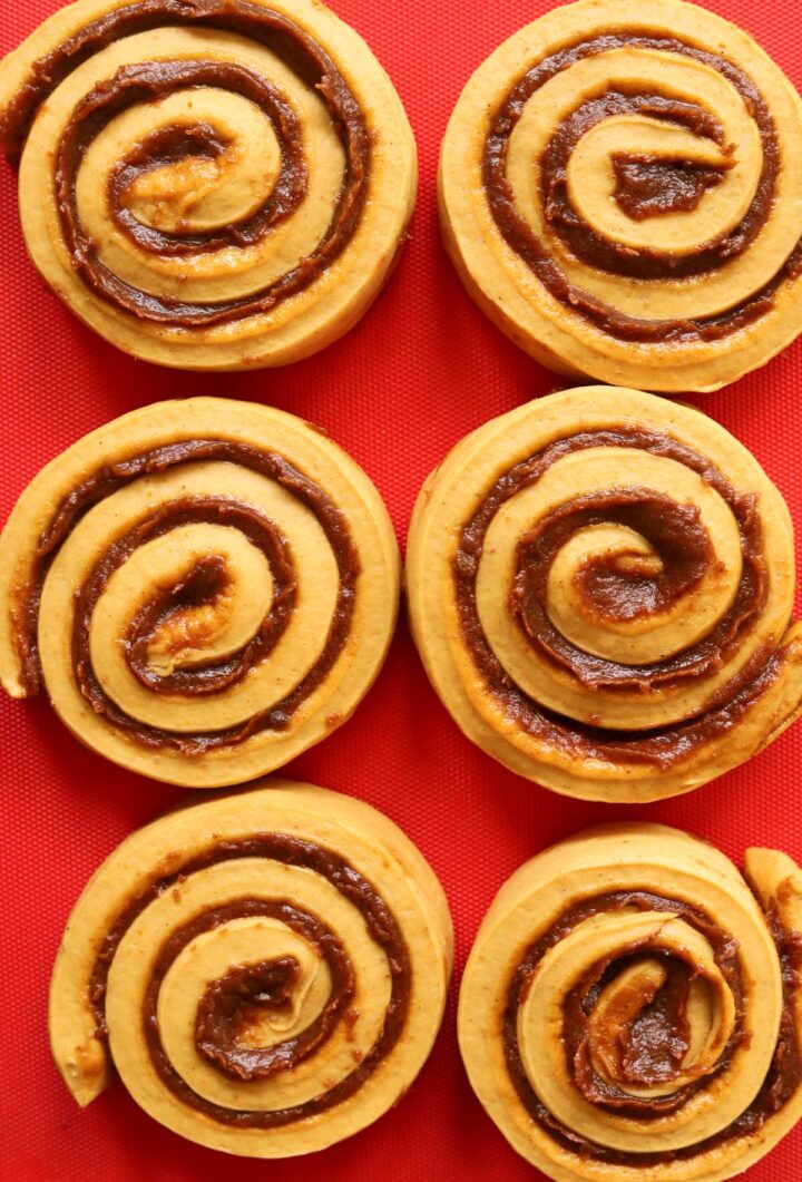 best pumpkin cinnamon roll dough rolled up with pumpkin cinnamon filling before proofing