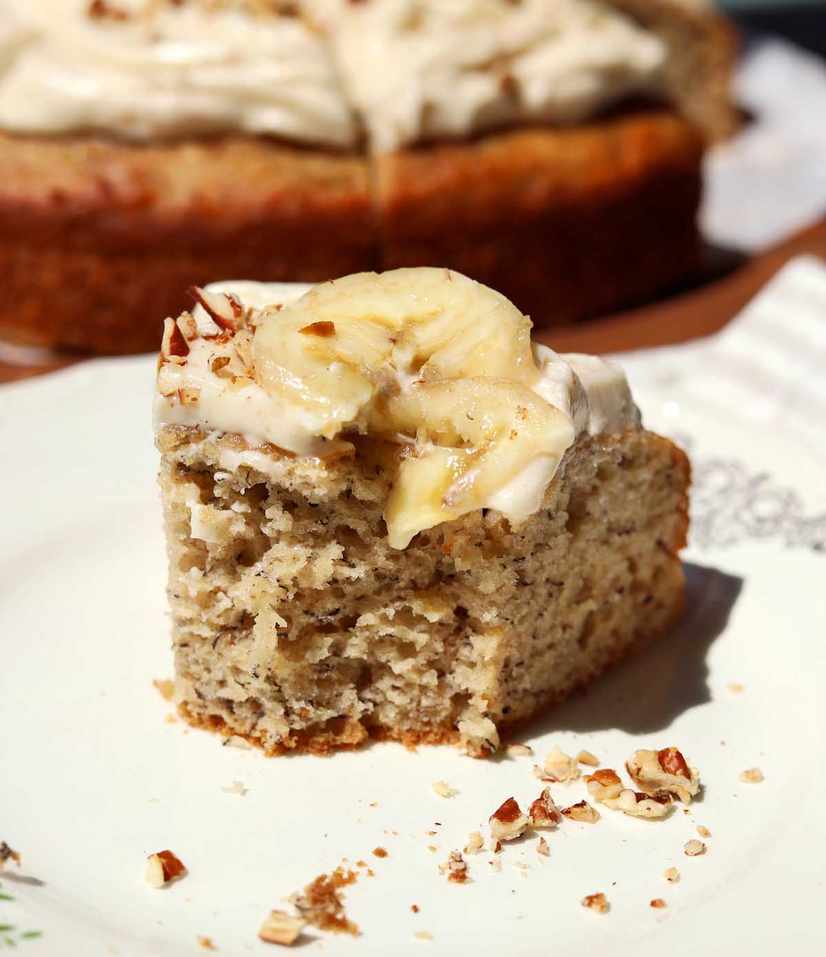 brown butter banana cake slice on a plate with bite showing soft texture