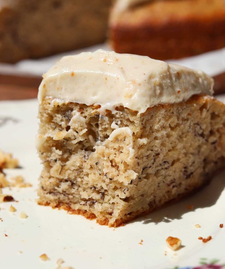 brown butter banana cake slice on a plate with bite showing soft texture