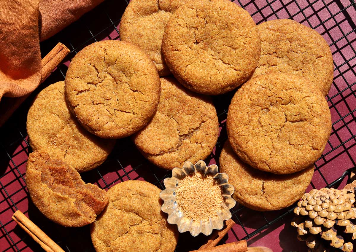 salted maple brown butter pumpkin cookies stacked on wire cooling rack with cinnamon sugar