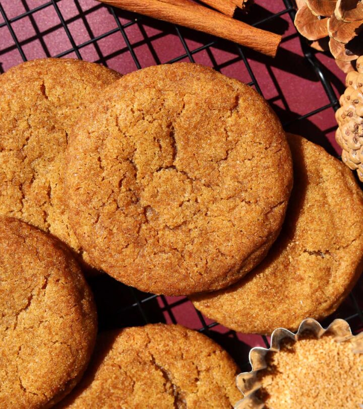 salted maple brown butter pumpkin cookies stacked on wire cooling rack with cinnamon sugar