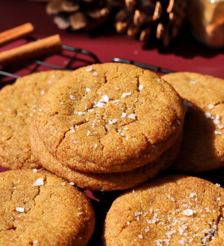 salted maple brown butter pumpkin cookies stacked on wire cooling rack with flaky sea salt