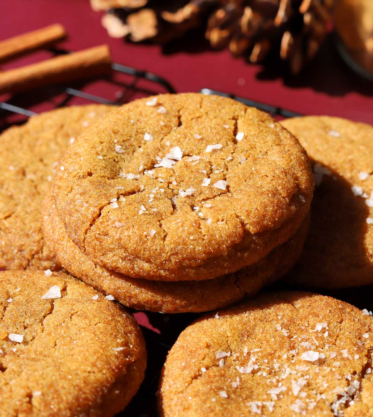 salted maple brown butter pumpkin cookies stacked on wire cooling rack with flaky sea salt
