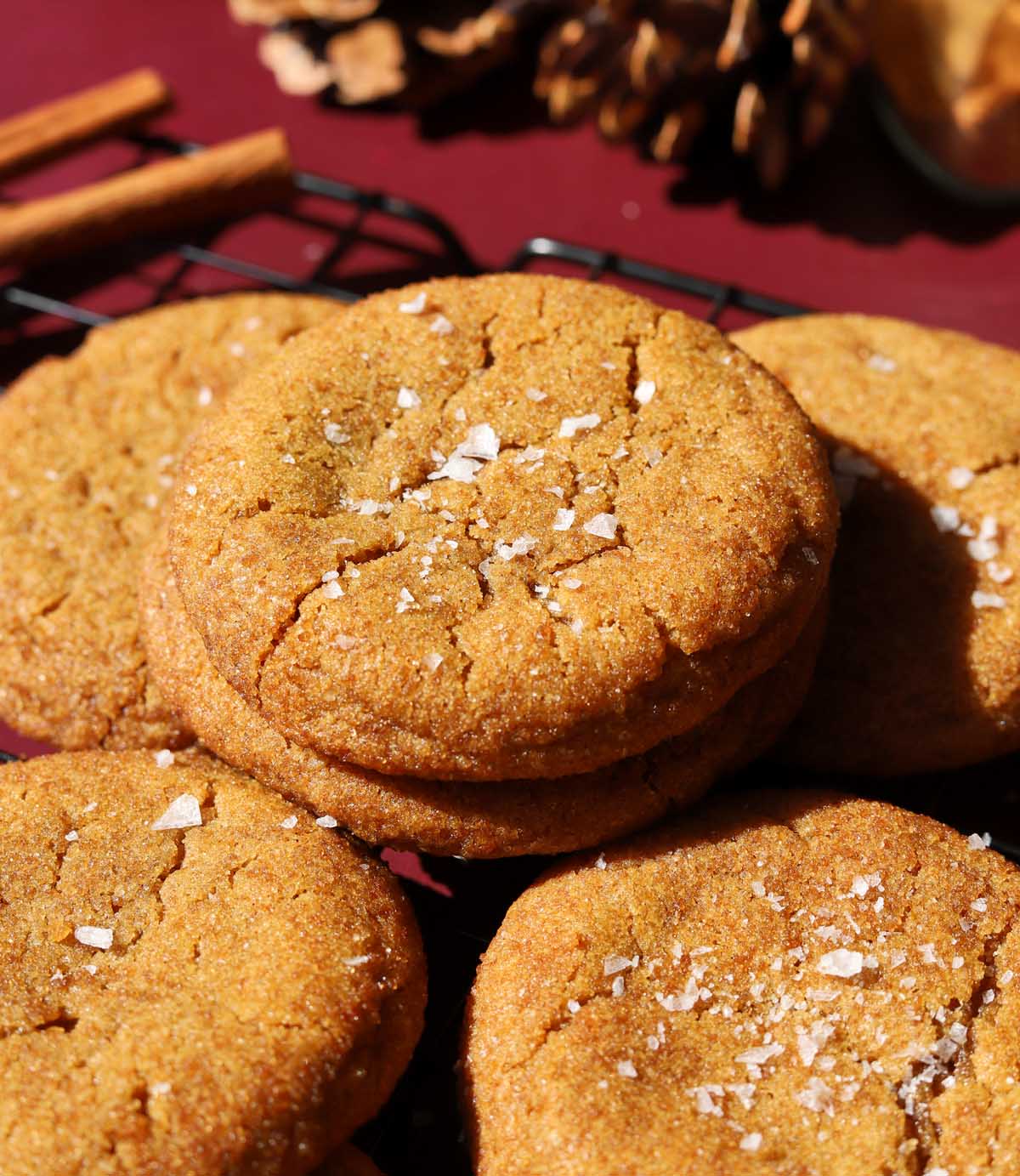 salted maple brown butter pumpkin cookies stacked on wire cooling rack with flaky sea salt
