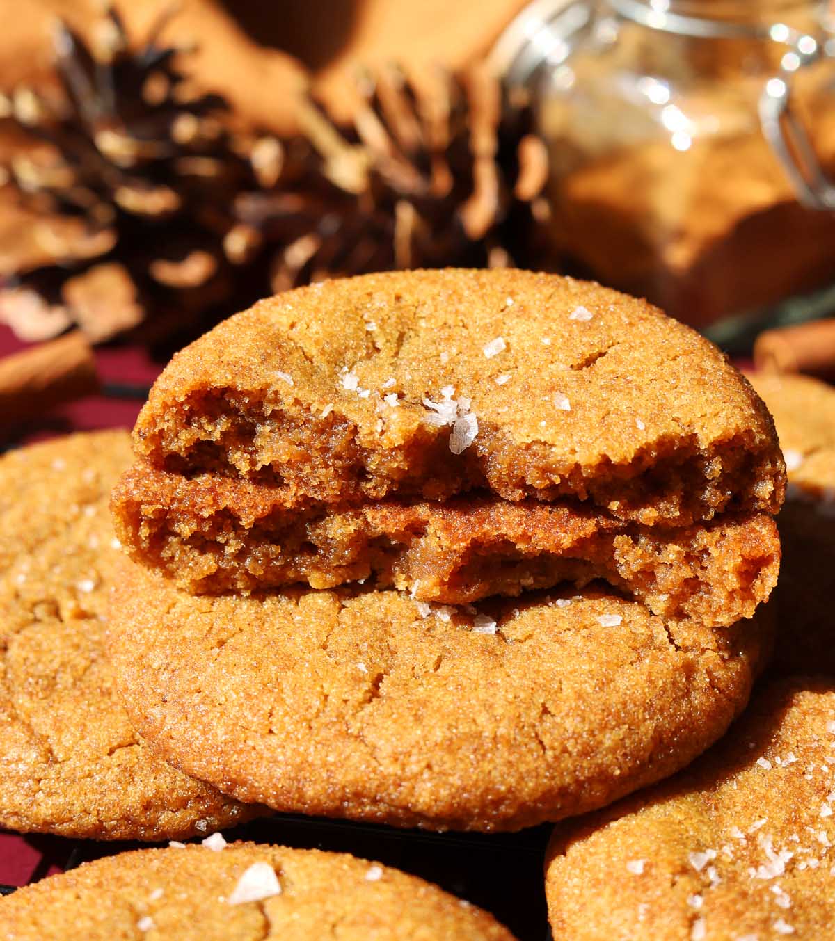 salted maple brown butter pumpkin cookies broken in half stacked on wire cooling rack showing chewy texture