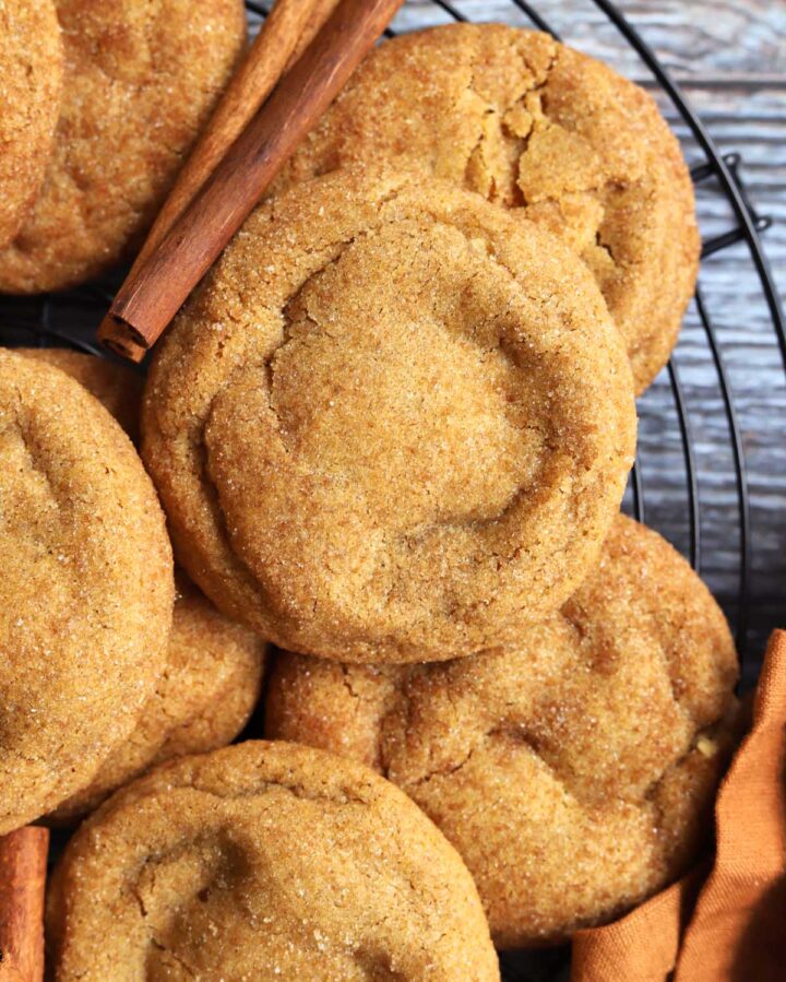 pumpkin cheesecake cookies piled up on cooling rack 