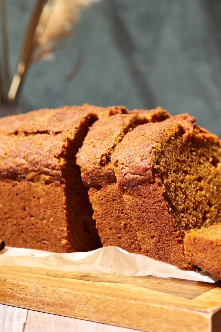 side view of best moist pumpkin bread sliced on cutting board