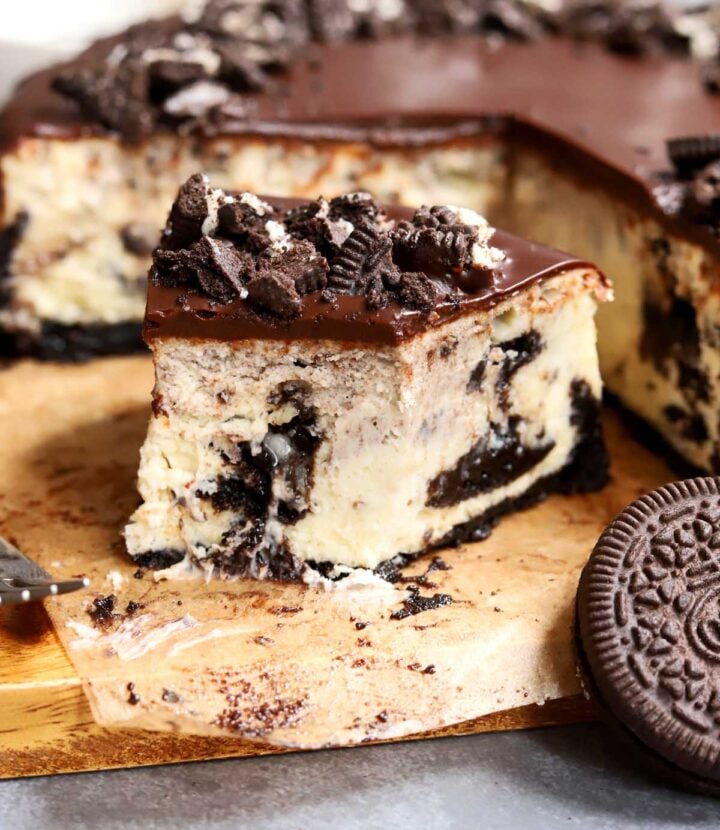 Oreo cookies & cream cheesecake slice on a board with bite