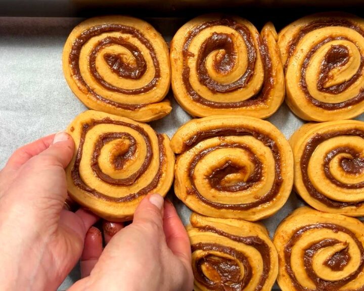 Arrange cinnamon scrolls in greased baking pan.