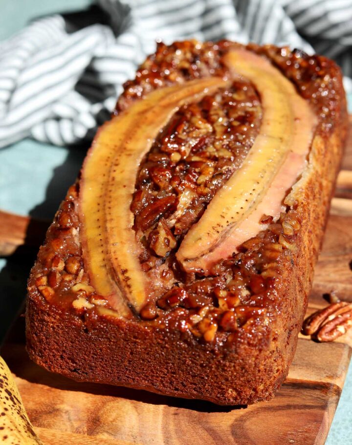 angle view of sticky caramelized pecan banana bread on cutting board