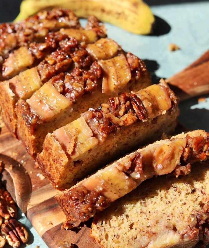 sticky caramelized pecan banana bread sliced on cutting board
