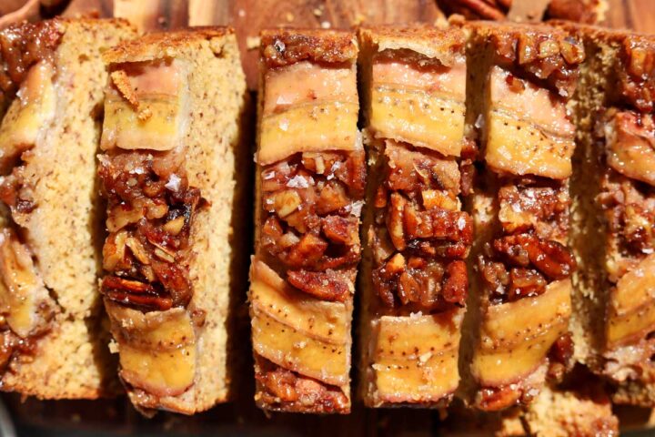 top view of sticky caramelized pecan banana bread sliced on cutting board