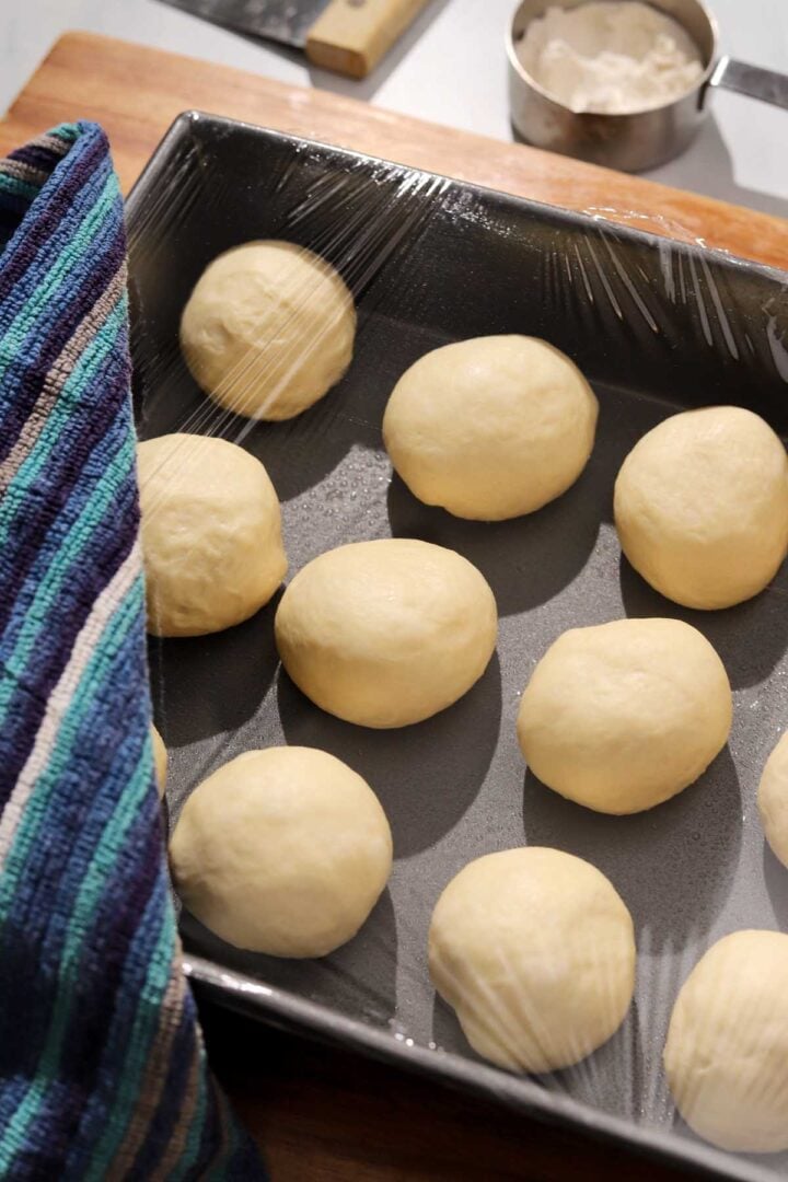 angle view of homemade dinner rolls dough balls in baking pan before proofing