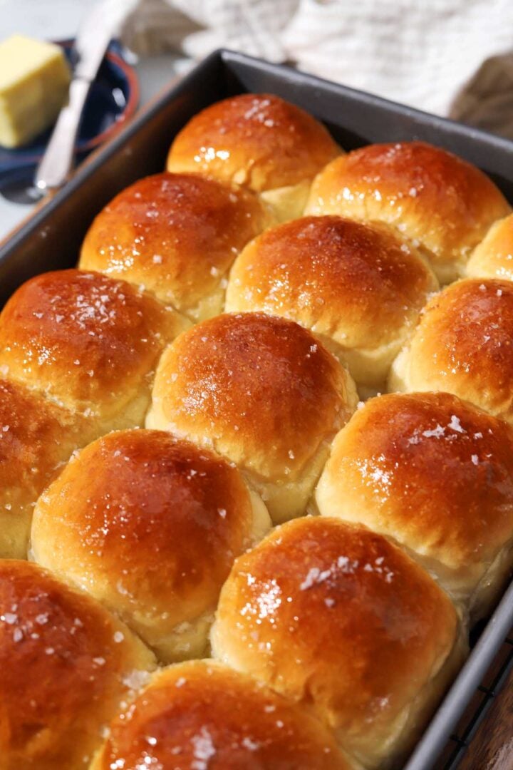 angle view of soft homemade dinner rolls in baking pan