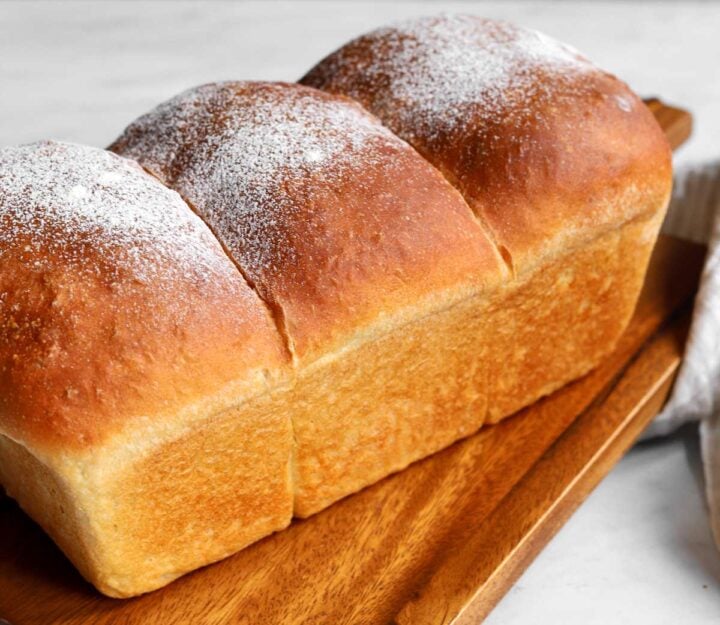 homemade sandwich bread loaf on cutting board before slicing