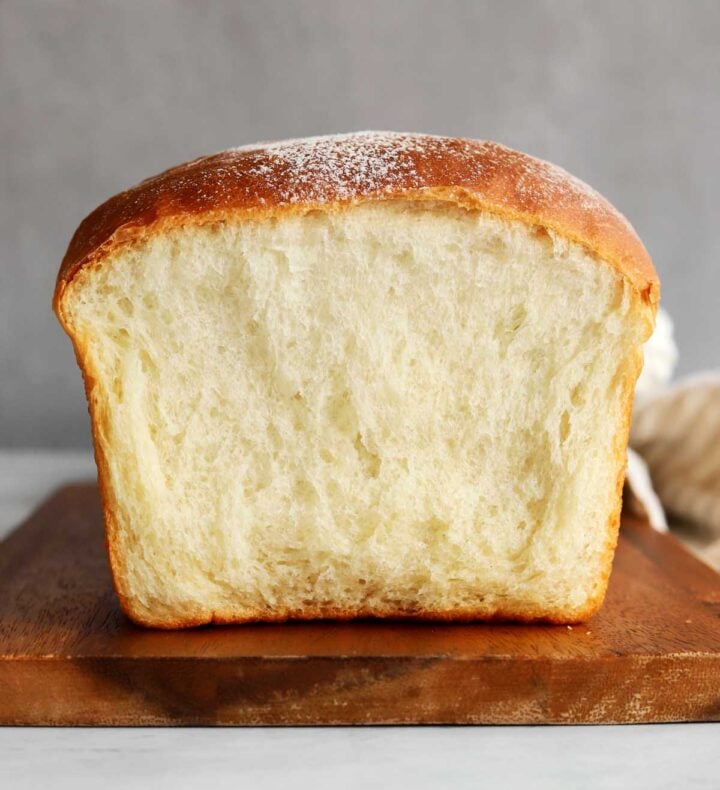 homemade sandwich loaf bread on cutting board showing fluffy soft interior