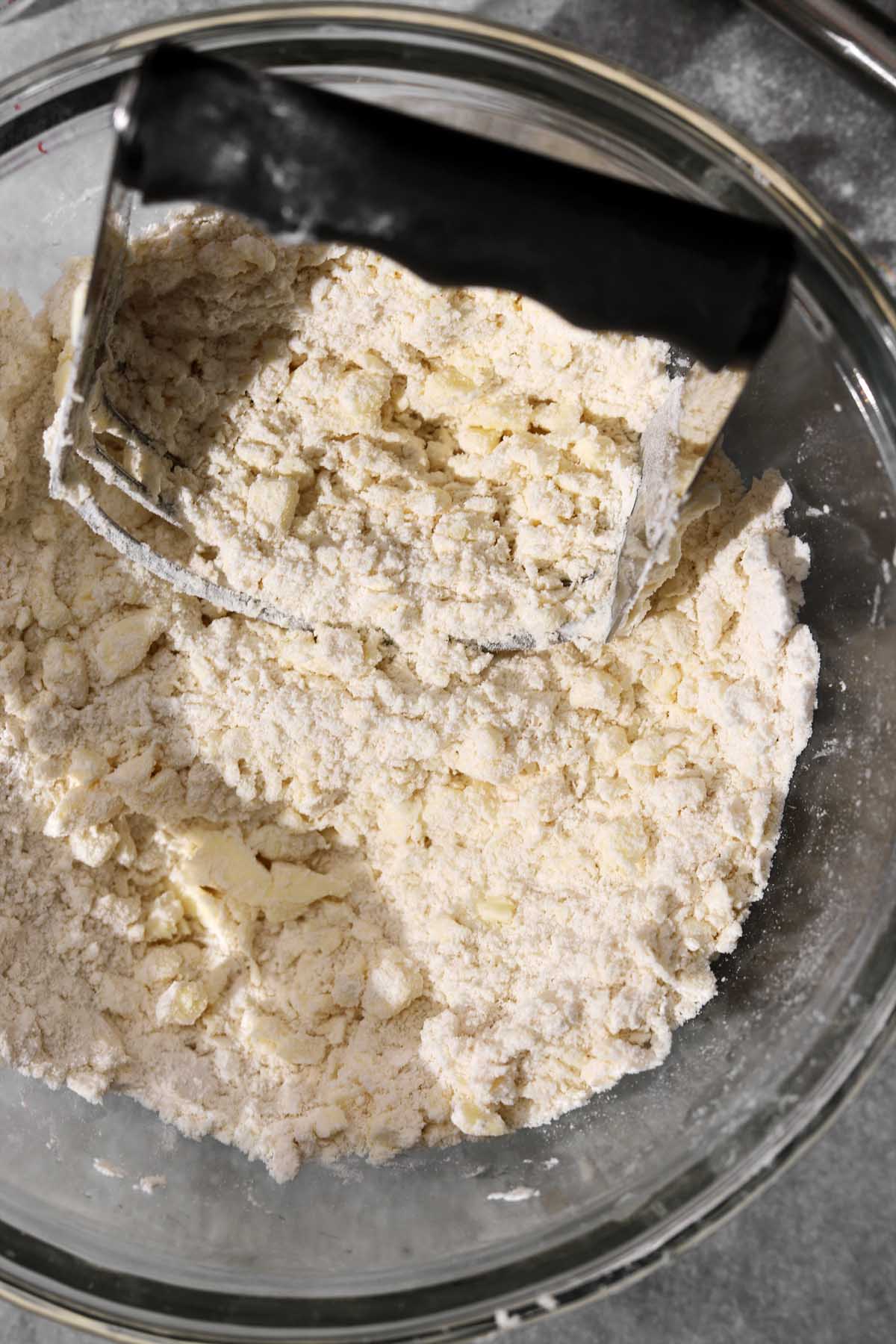Cutting in remaining butter in larger pieces.