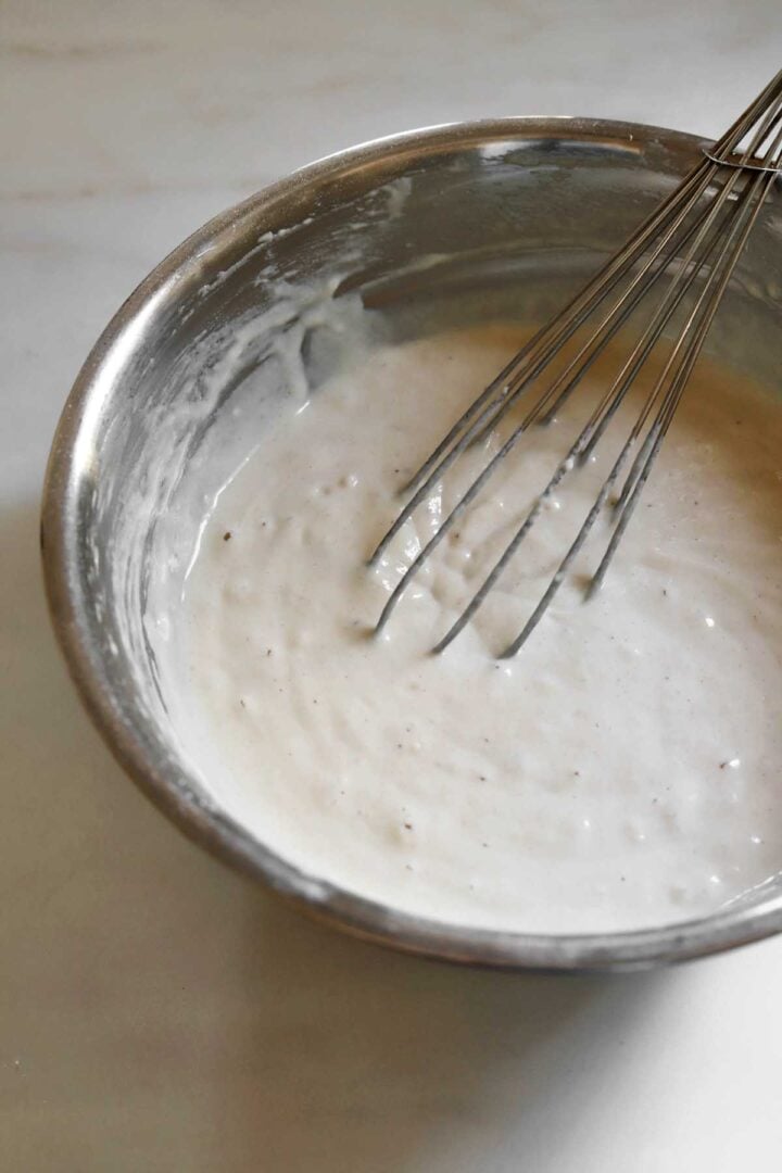 egg white pancake batter in a bowl with a whisk