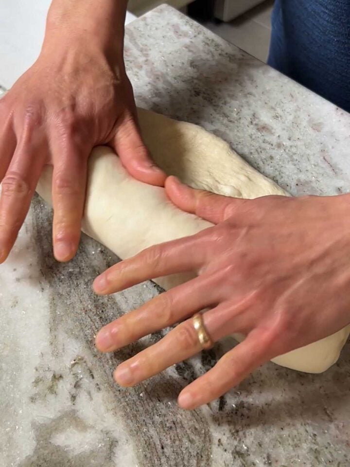 Use your thumbs to pull the dough tightly and create tension.